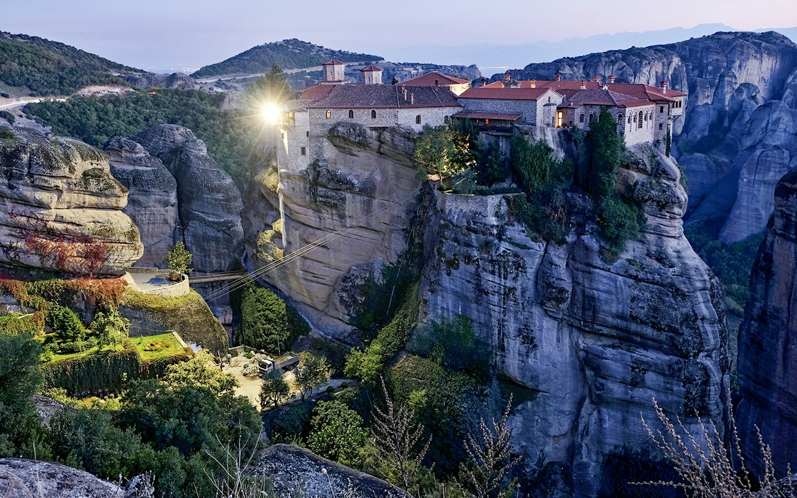 Monastery of Varlaam illuminated at night atop rock formations in Meteora, Greece.