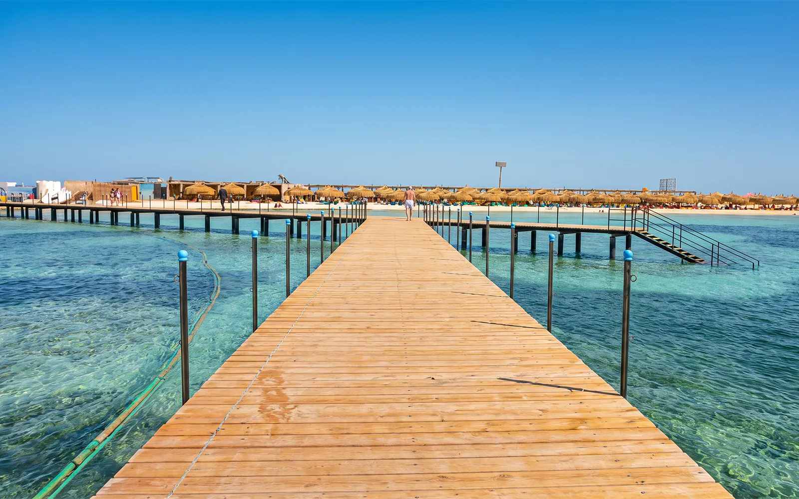 Wooden pier leading to Bianca Island beach in Hurghada with clear blue water.