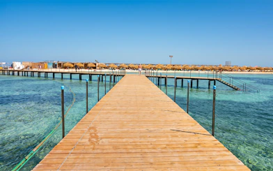 Wooden pier leading to Bianca Island beach in Hurghada with clear blue water.