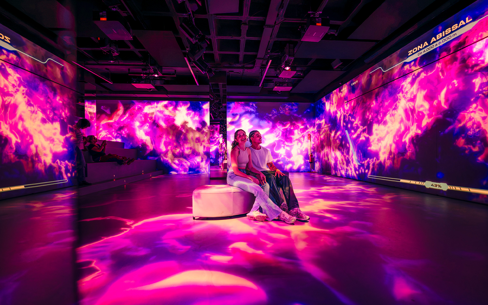 Tourists enjoying immersive AV room at Barcelona Aquarium.