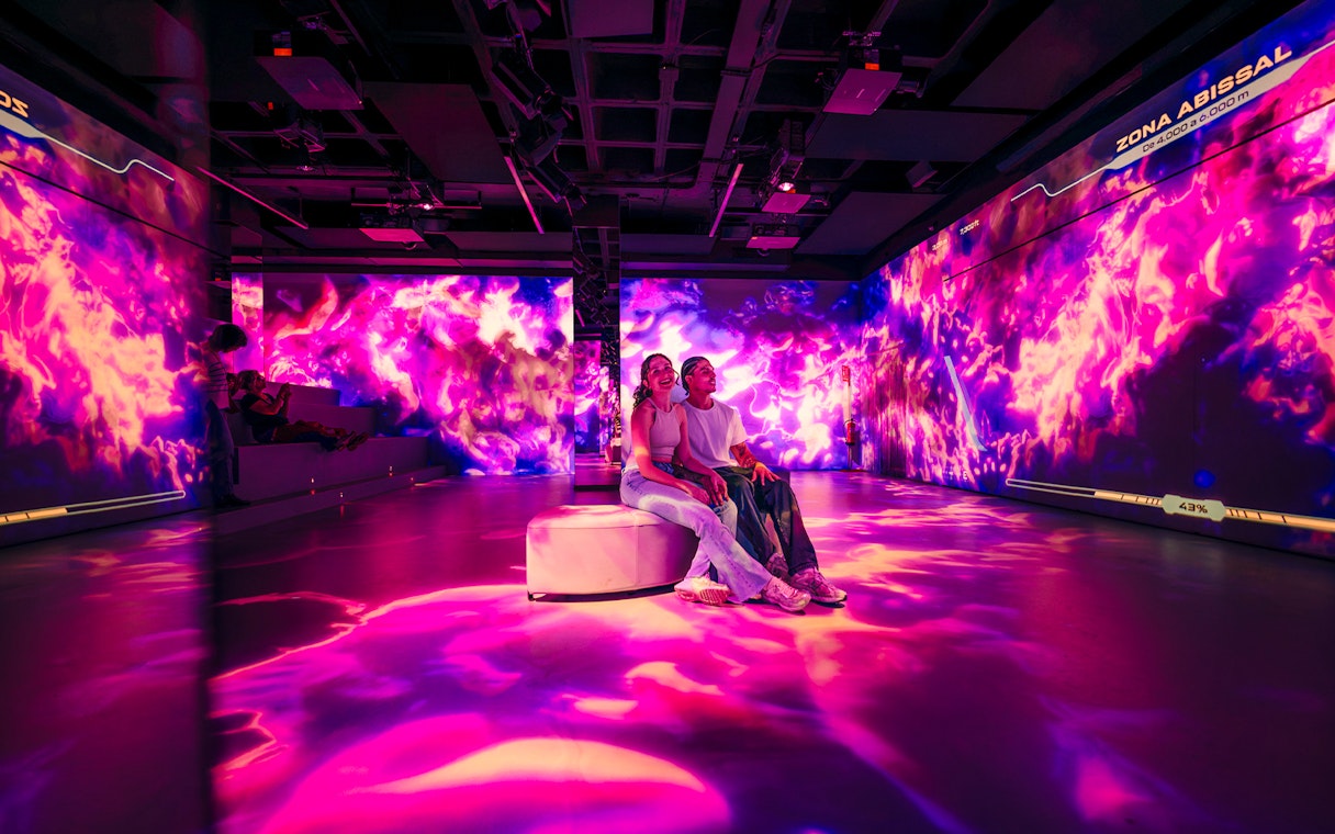 Tourists enjoying immersive AV room at Barcelona Aquarium.