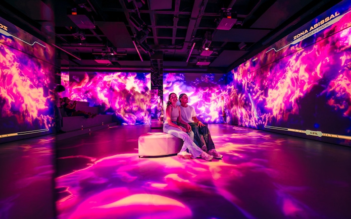 Tourists enjoying immersive AV room at Barcelona Aquarium.