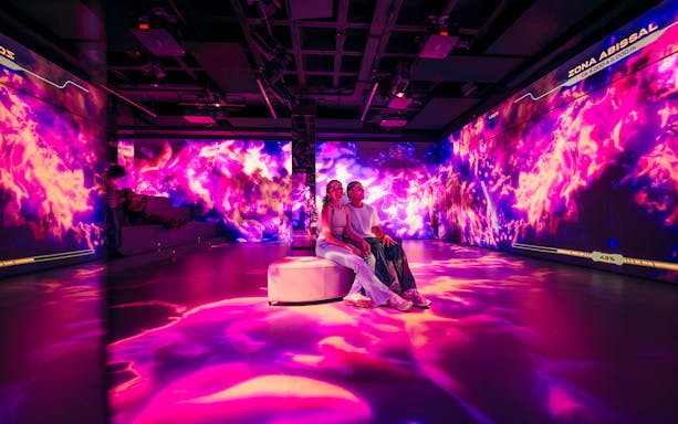 Tourists enjoying immersive AV room at Barcelona Aquarium.