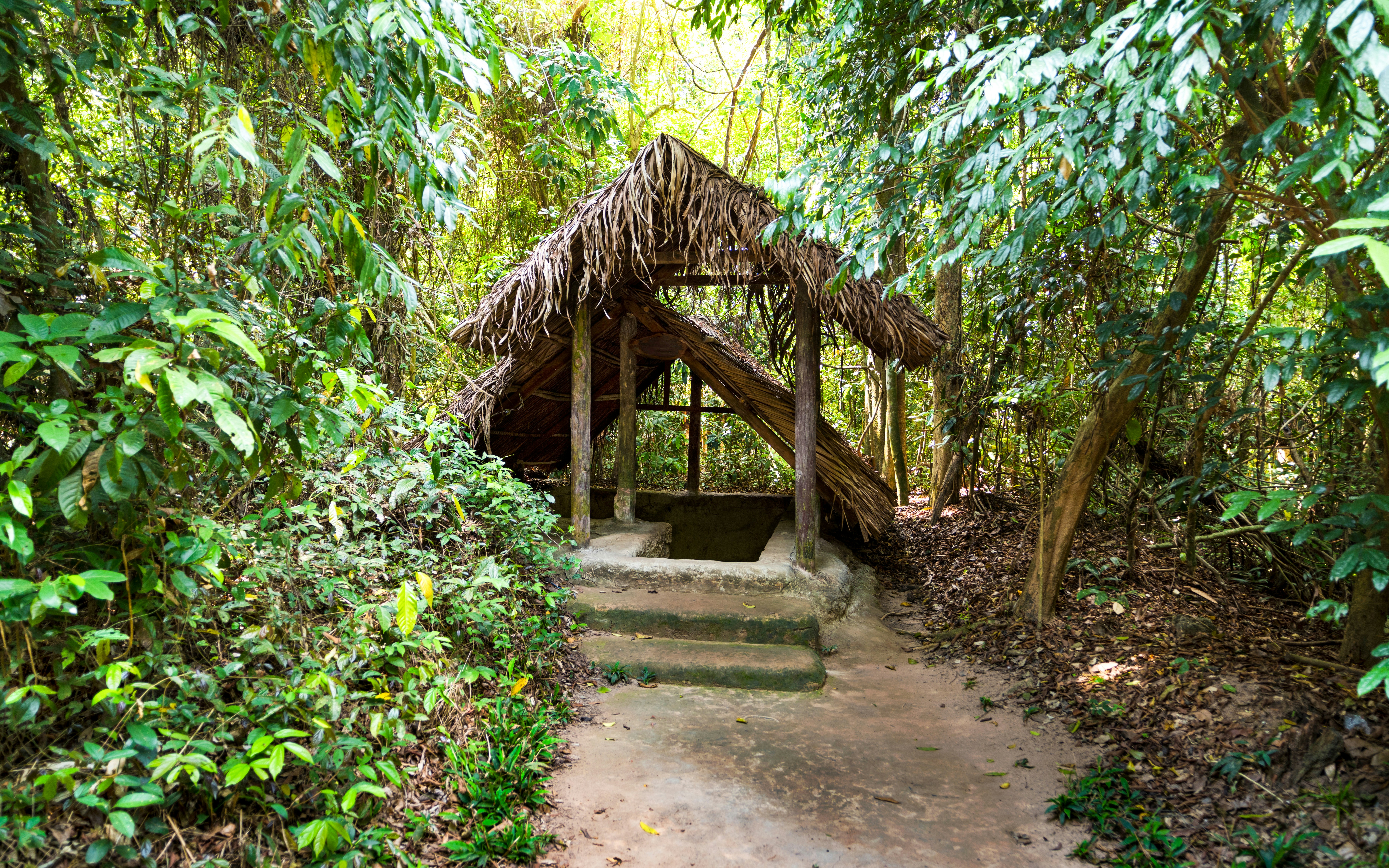 People exploring underground passageways and historical exhibits, Cu chi tunnel