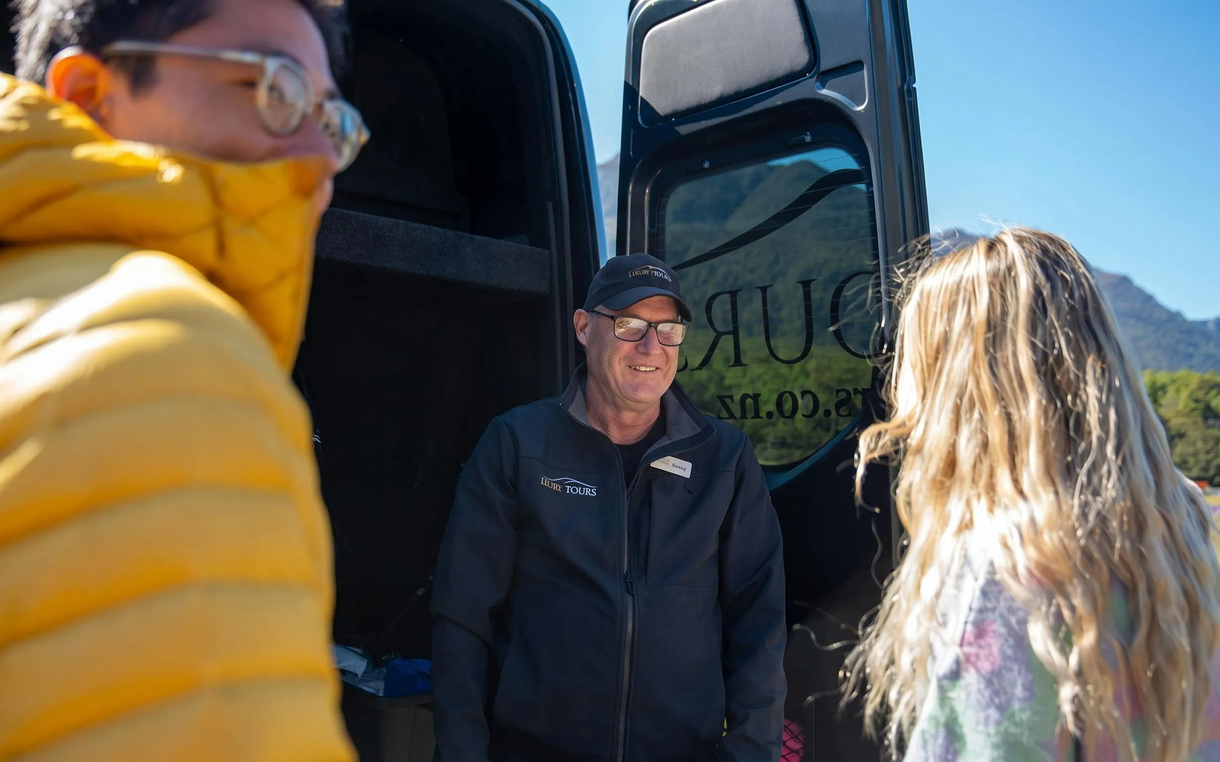 Tour guide greeting visitors at Milford Sound Day Tour departure from Te Anau.