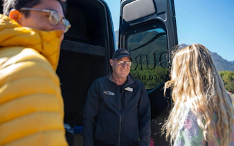 Tour guide greeting visitors at Milford Sound Day Tour departure from Te Anau.
