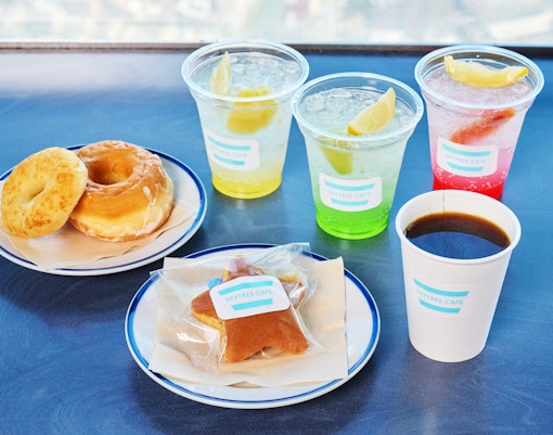 Tokyo Skytree cafe platter with soft drinks and snacks, city view in background.