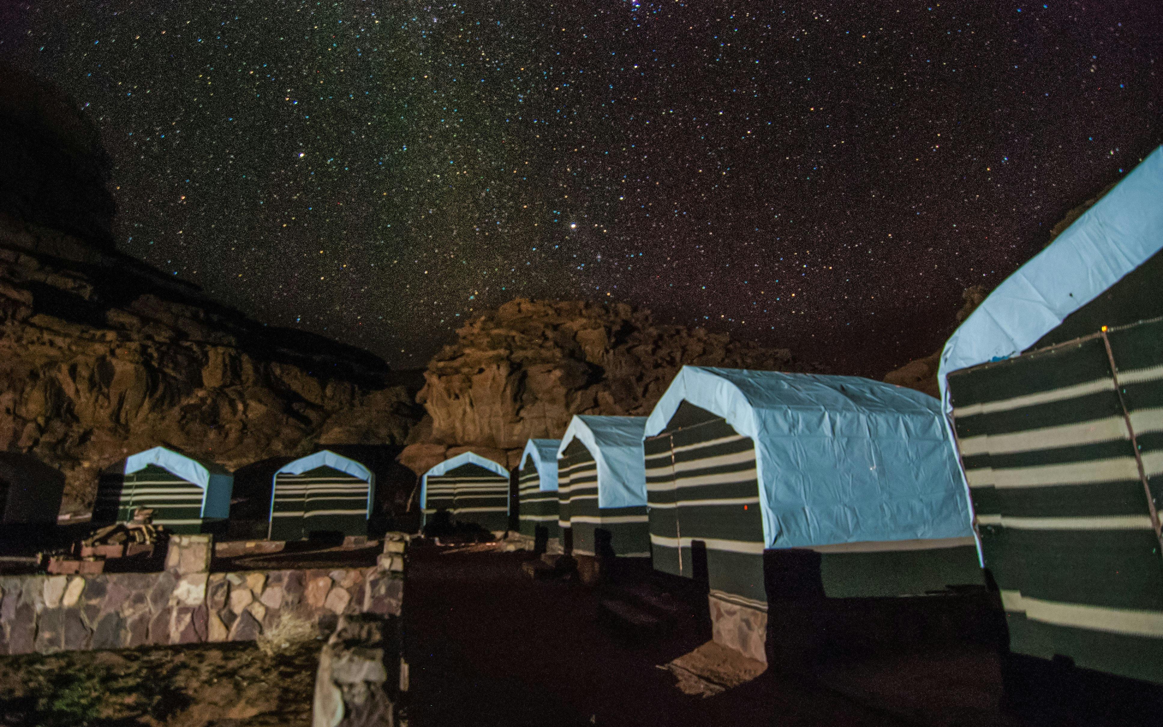Bedouin tents under starry sky in Wadi Rum desert, Jordan.