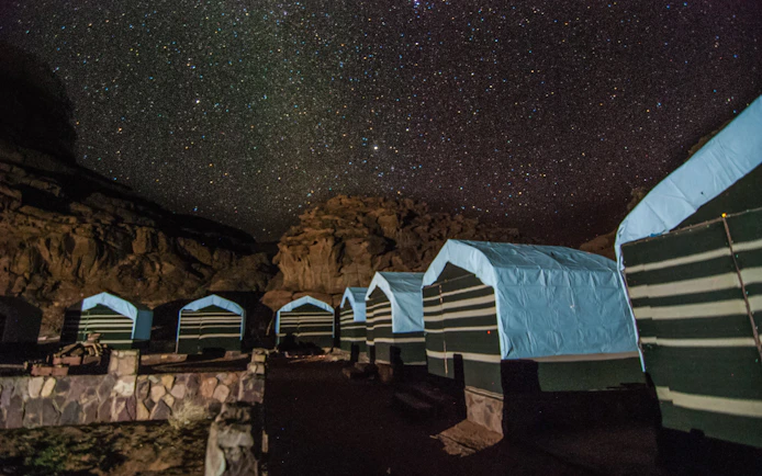 Bedouin tents under starry sky in Wadi Rum desert, Jordan.
