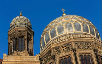 Berlin New Synagogue domes against blue sky, part of Jewish District exploration game.
