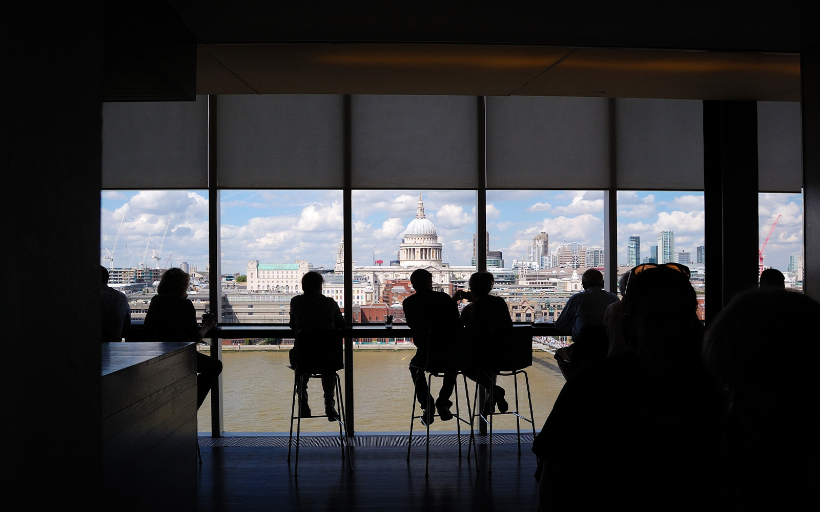 People enjoying the London skyline view from Tate Modern, featuring St. Paul's Cathedral.