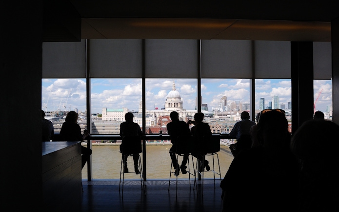 People enjoying the London skyline view from Tate Modern, featuring St. Paul's Cathedral.