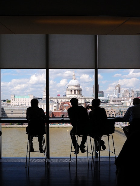 People enjoying the London skyline view from Tate Modern, featuring St. Paul's Cathedral.