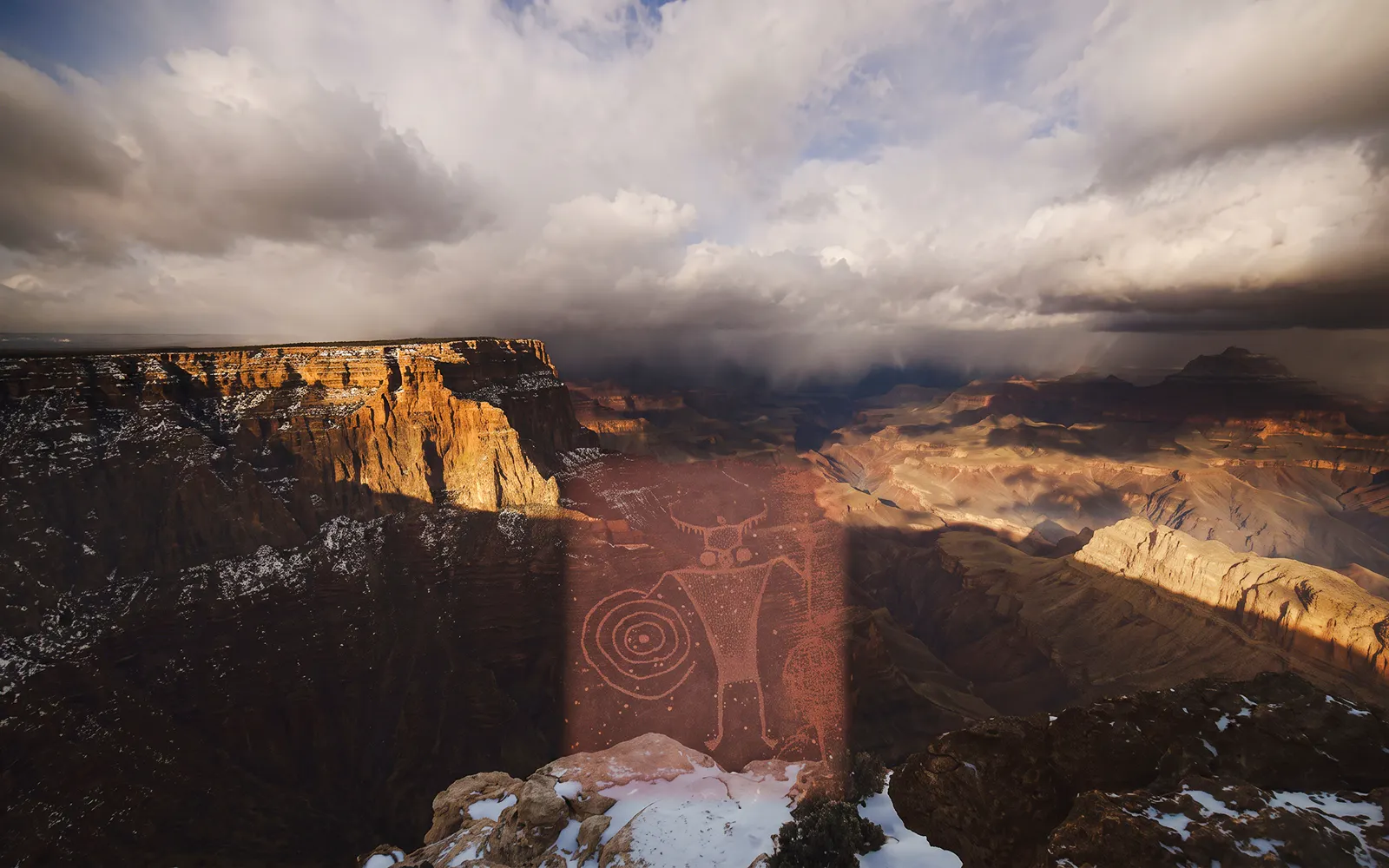 Grand Canyon landscape with ancient petroglyphs under dramatic clouds.