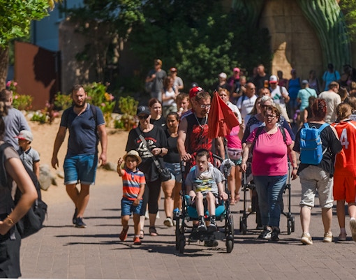 Visitors at Phantasialand in Cologne, including a person in a wheelchair, enjoying the park.