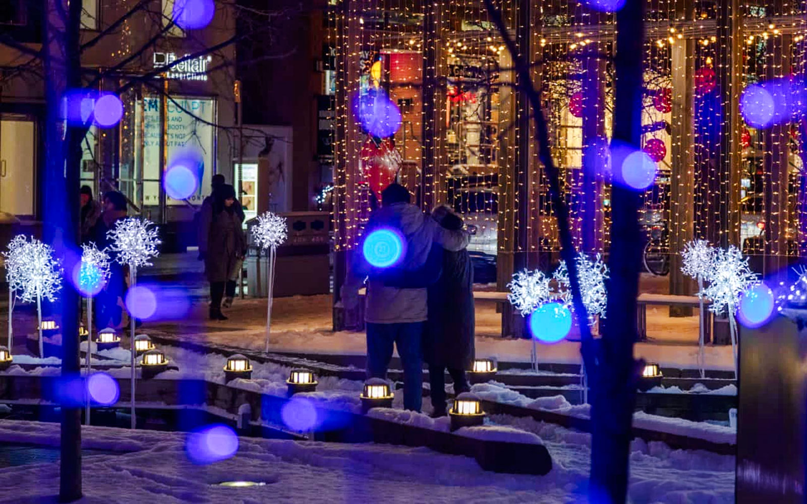 Festive light installation with blue and white lights in snowy Toronto.