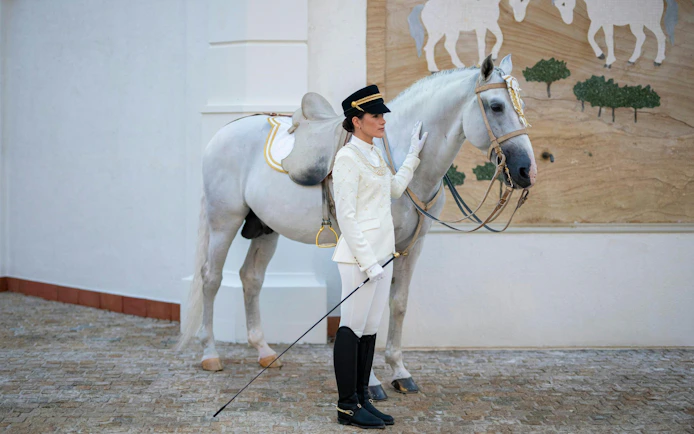 Equestrian performer with white horse at Abu Dhabi Royal Equestrian Arts tour.