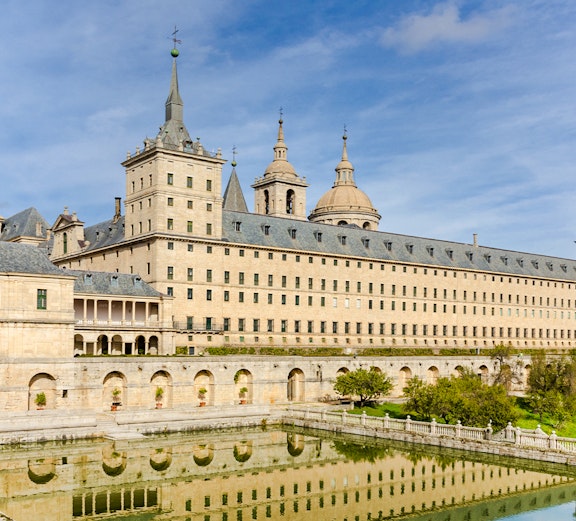El Escorial monastery and palace in San Lorenzo de El Escorial, Spain, reflected in a pond.