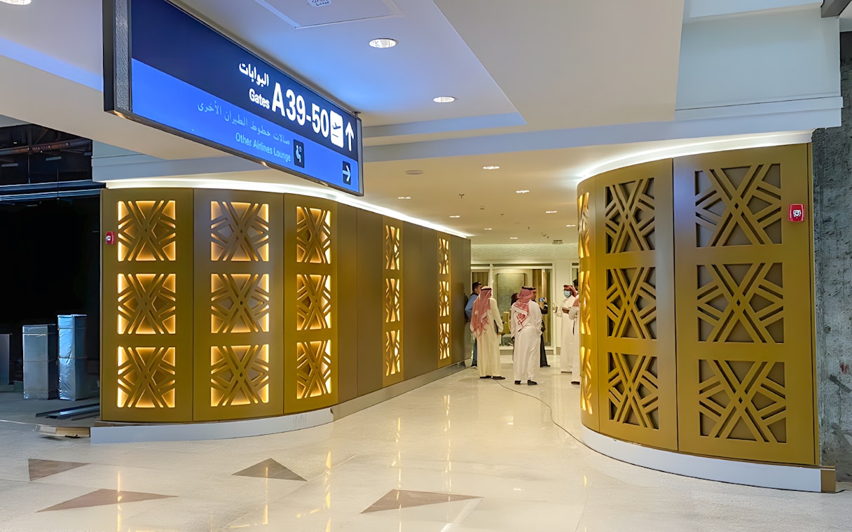 Premium lounge entrance at Jeddah Airport with people nearby.