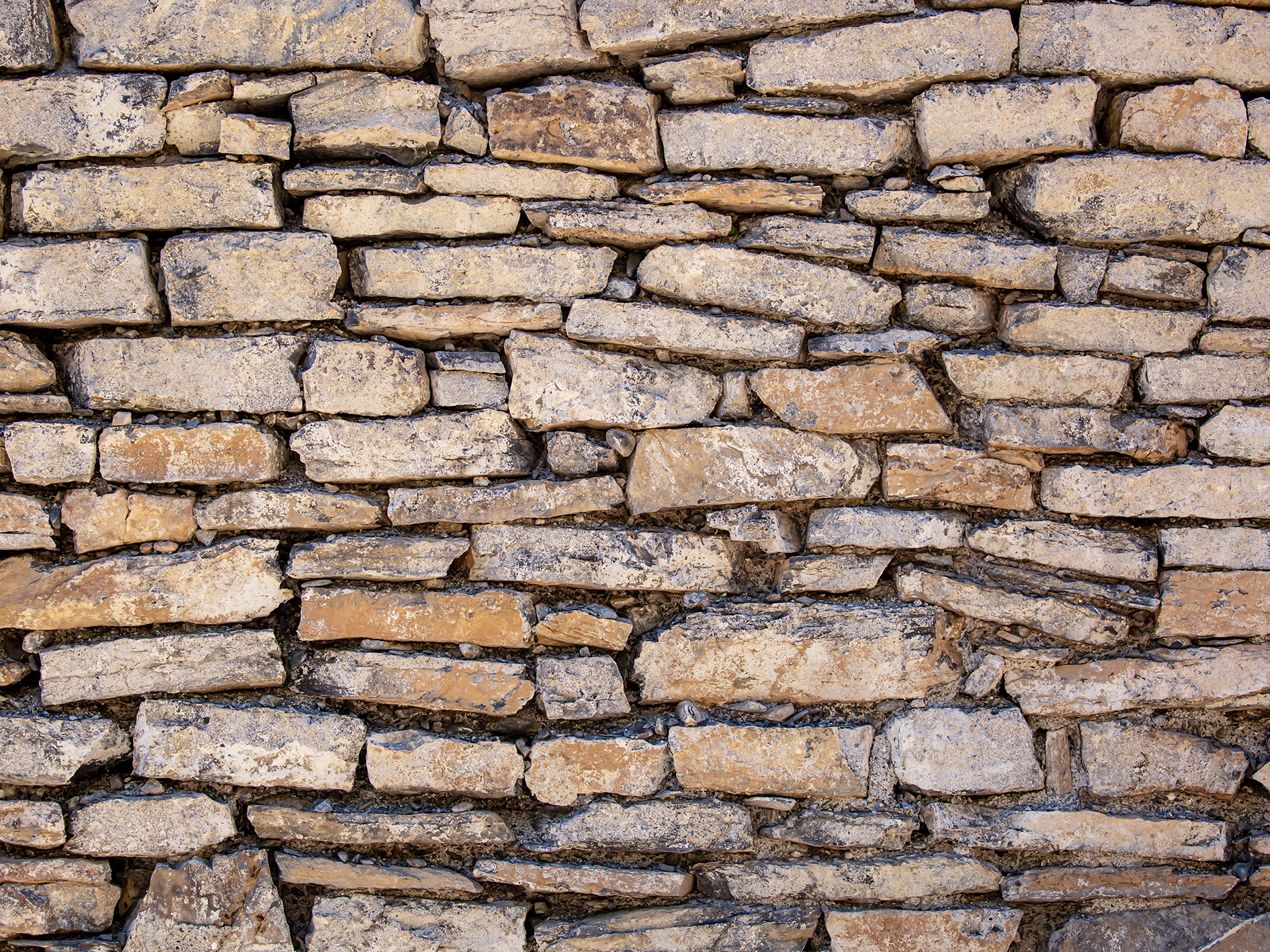 Stone antique old wall with different kinds of rocks and stones