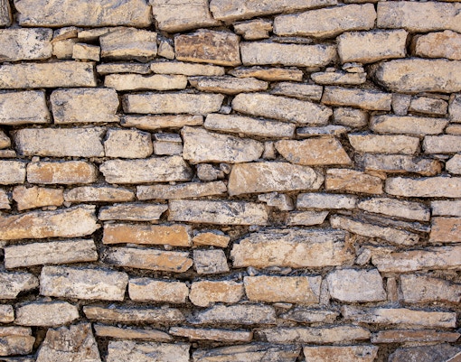 Stone antique old wall with different kinds of rocks and stones