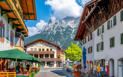 Old town street in Hallstatt with traditional buildings and mountain backdrop.