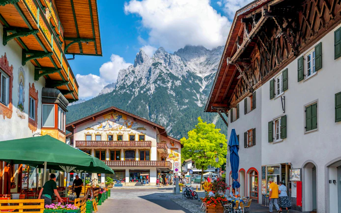 Old town street in Hallstatt with traditional buildings and mountain backdrop.