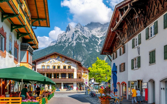 Old town street in Hallstatt with traditional buildings and mountain backdrop.