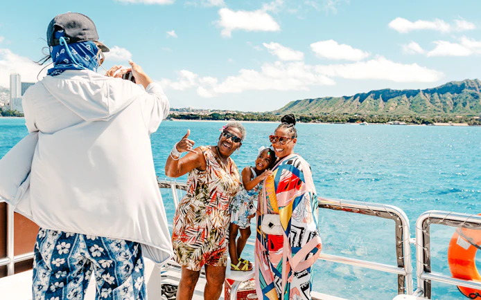 Group enjoying a glass-bottom boat tour near Waikiki with Diamond Head in the background.