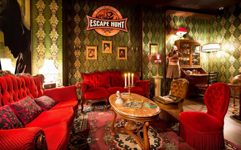 Escape room with vintage decor and red sofas in Dubai's Aladdin & The Magic Vault experience.