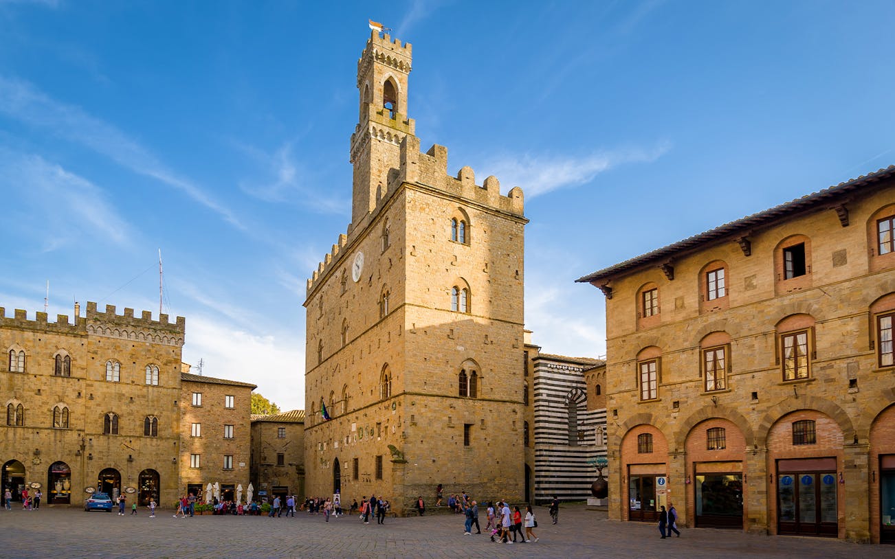 Piazza dei Priori in Volterra with historic buildings and clock tower.