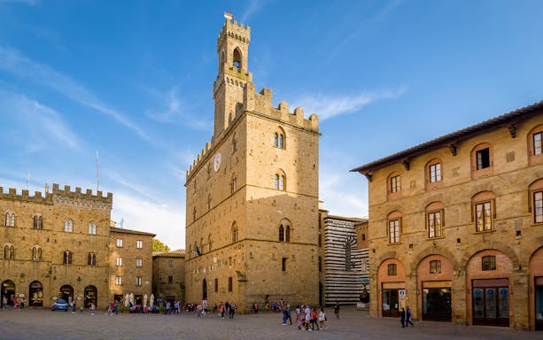 Piazza dei Priori in Volterra with historic buildings and clock tower.