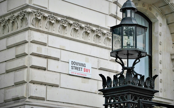 Downing Street sign and ornate lamp post in Westminster, London.