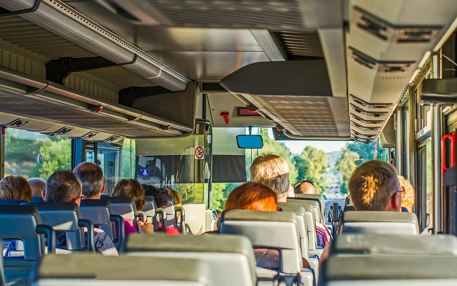 Passengers seated in an air-conditioned coach during a scenic tour.