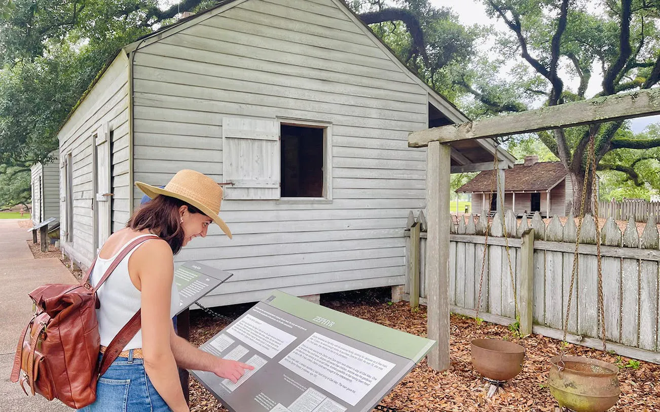 Visitor reading informational sign at Oak Alley Plantation, New Orleans.