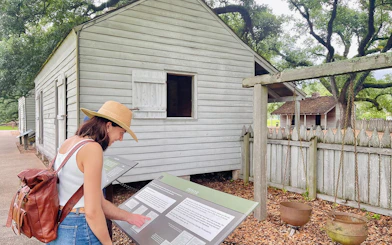 Visitor reading informational sign at Oak Alley Plantation, New Orleans.