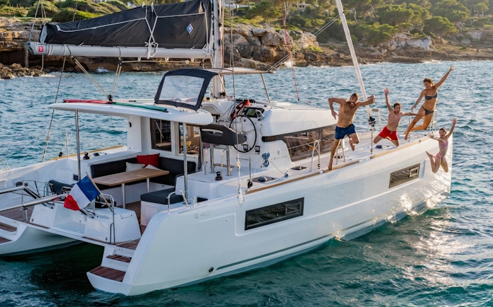 Group enjoying a catamaran tour in La Maddalena, jumping into the sea.
