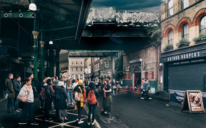 Group of tourists at Borough Market, a Harry Potter film location in London.