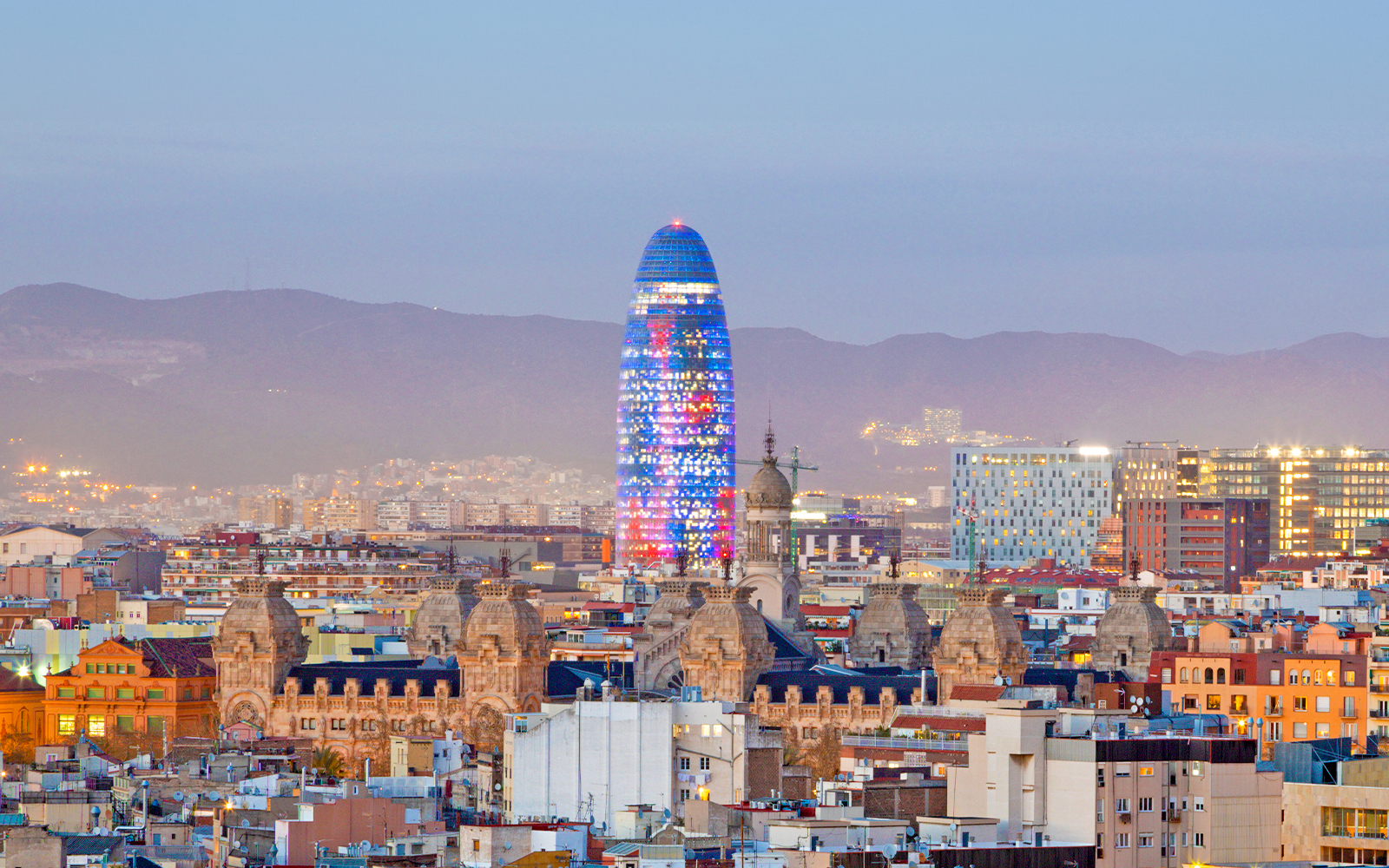 Torre Glòries illuminated at night in Barcelona, Spain.