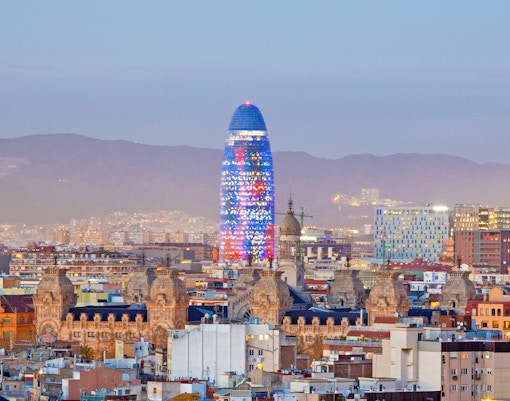 Torre Glòries illuminated at night in Barcelona, Spain.