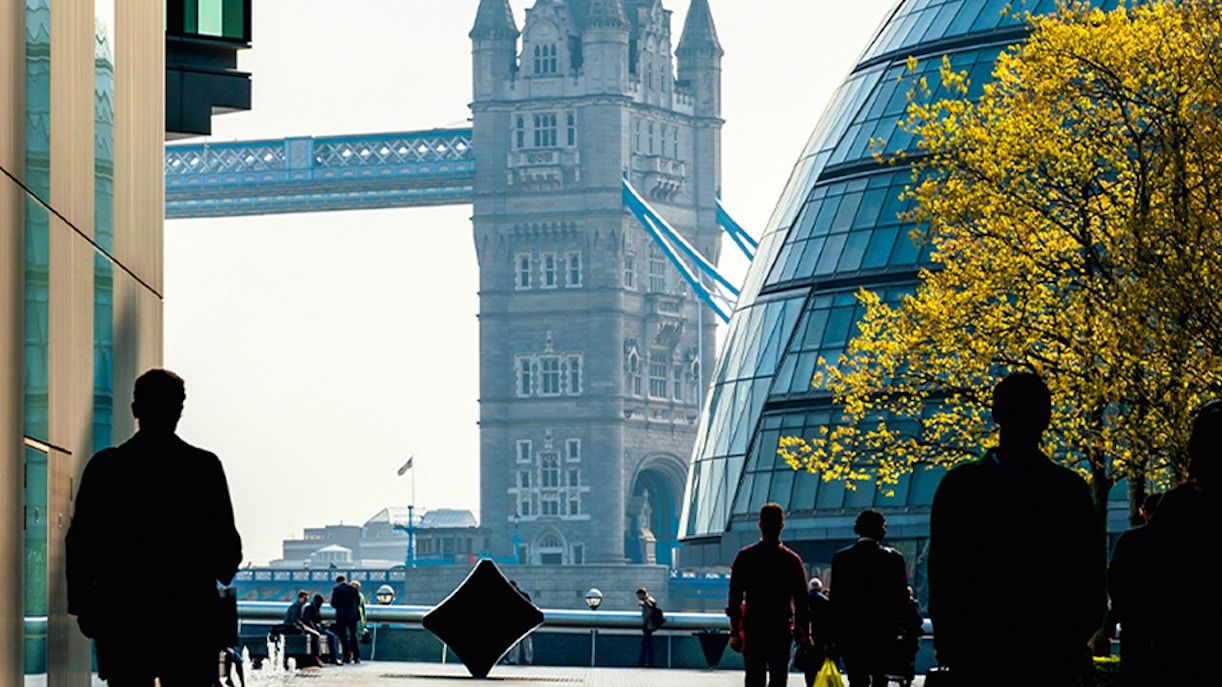 Tower Bridge view from a modern walkway in London with people walking.