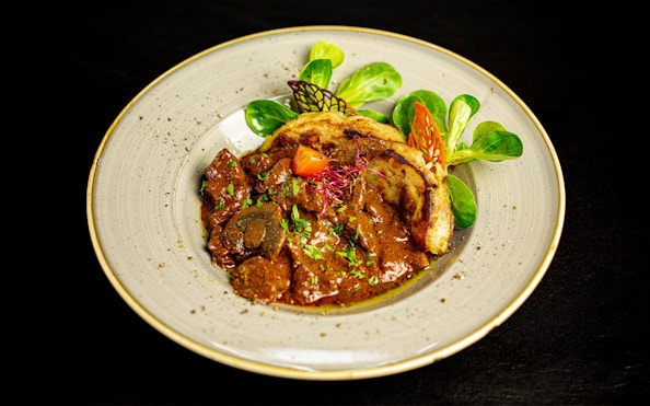 Hungarian goulash served on a Budapest dinner cruise with folk show.