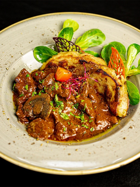 Hungarian goulash served on a Budapest dinner cruise with folk show.