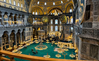Interior view of Hagia Sophia's grand dome and ornate chandeliers, Istanbul.