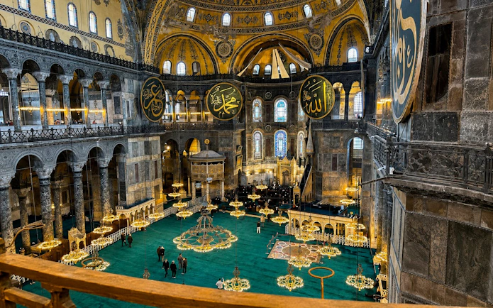 Interior view of Hagia Sophia's grand dome and ornate chandeliers, Istanbul.