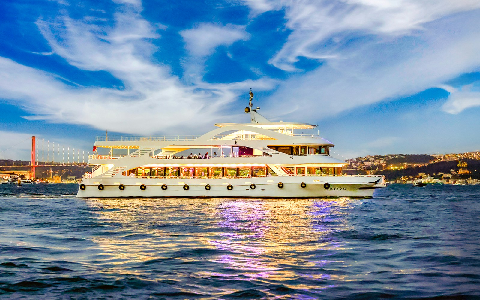Bosphorus 4-Course Dinner Cruise AMOR on Bosporus Strait during evening with city lights in background.