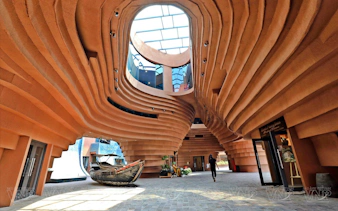 Curved architectural interior with boat display at Pottery Village, Ha Noi.