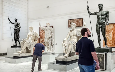 Visitors viewing classical statues at Naples National Archaeological Museum.