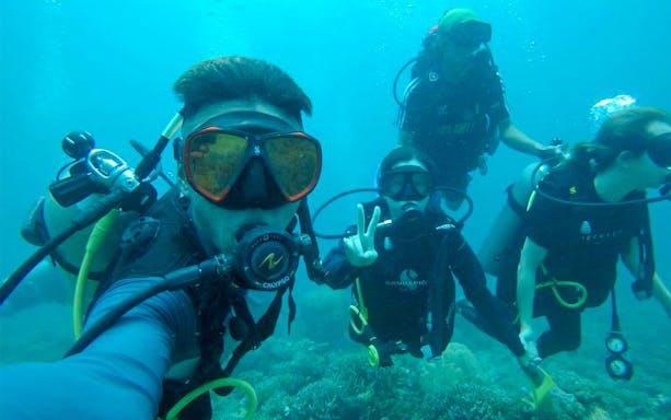 Scuba divers exploring underwater near Kawa Kawa River.