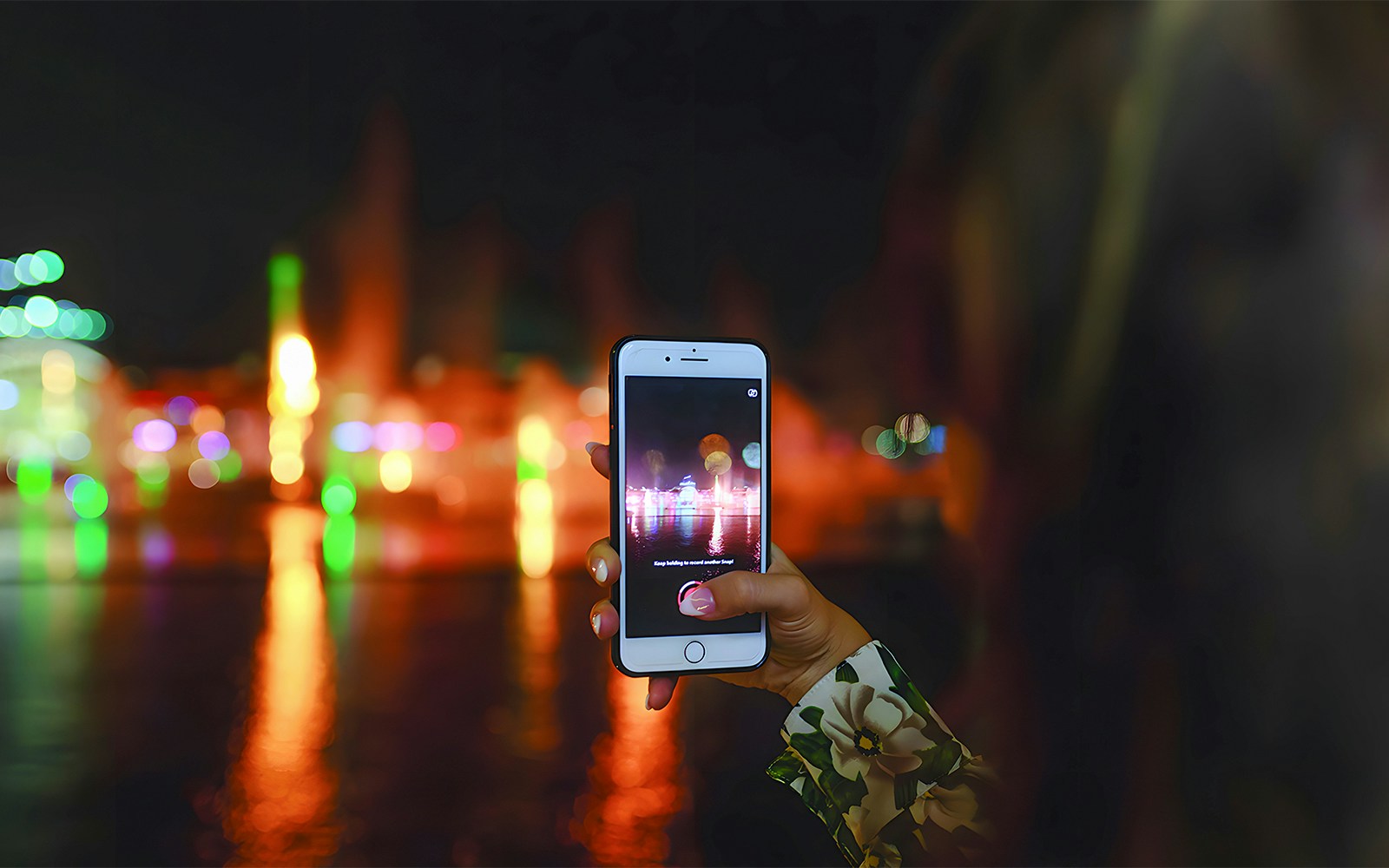 A woman taking a photo of the 'Imagine Show'